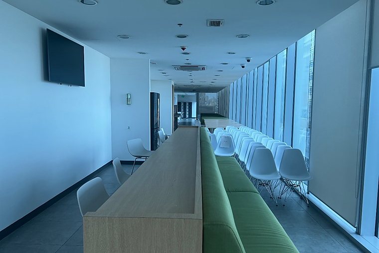 Shared space along the windows with counter seating, a sofa and chairs.