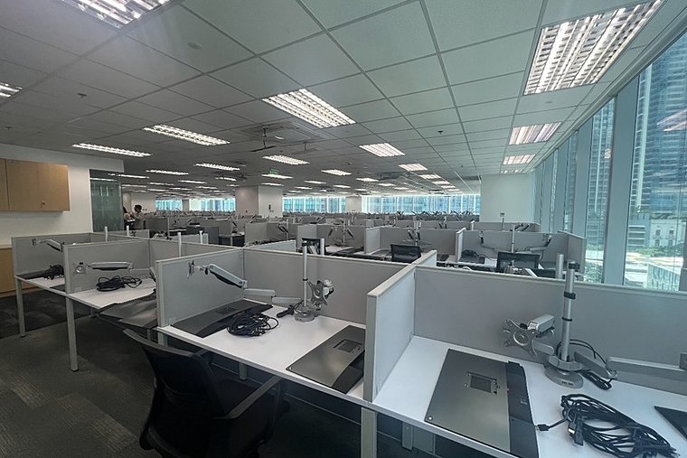 Work area facing the windows, with partitioned workstations and chairs.
